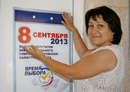 Член избирательной комиссии А.Дятлова размещает информационные материалы на участке 2106